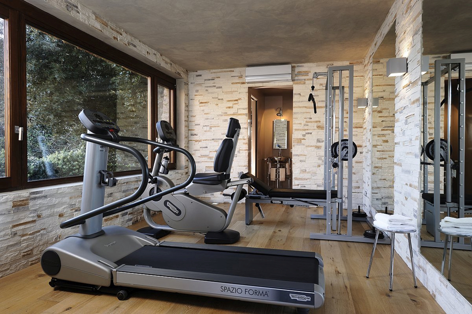Gym with equipment and large windows at La Feniglia in Porto Ercole in Tuscany
