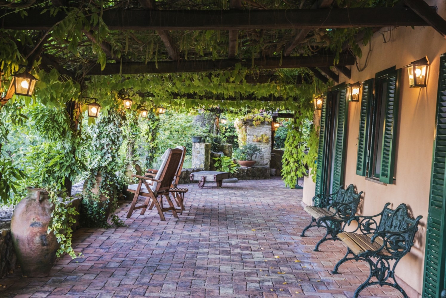 Terrace with vines, chairs, lanterns and shutters at La Feniglia in Porto Ercole in Tuscany