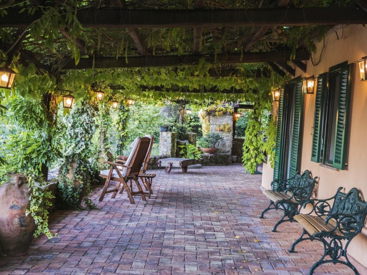 Terrace with vines, chairs, lanterns and shutters at La Feniglia in Porto Ercole in Tuscany