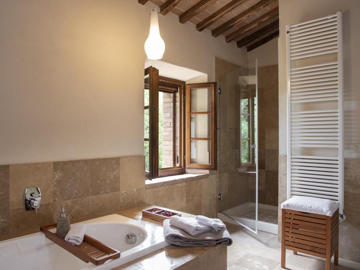 Bathroom with bath, towel rail and shower at La Gavelli in Tuscany, Italy