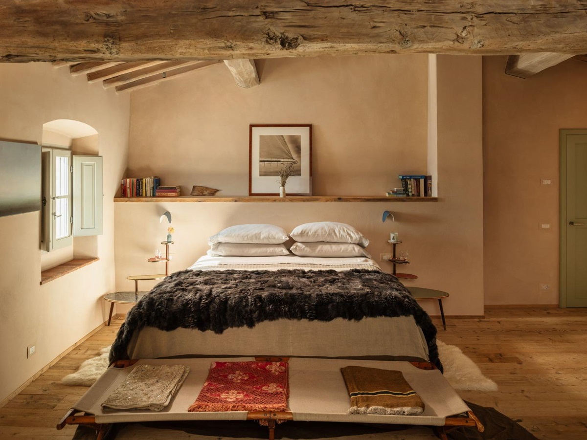 Large double bedroom with wooden floors and a window with shutters at La Regina in Tuscany