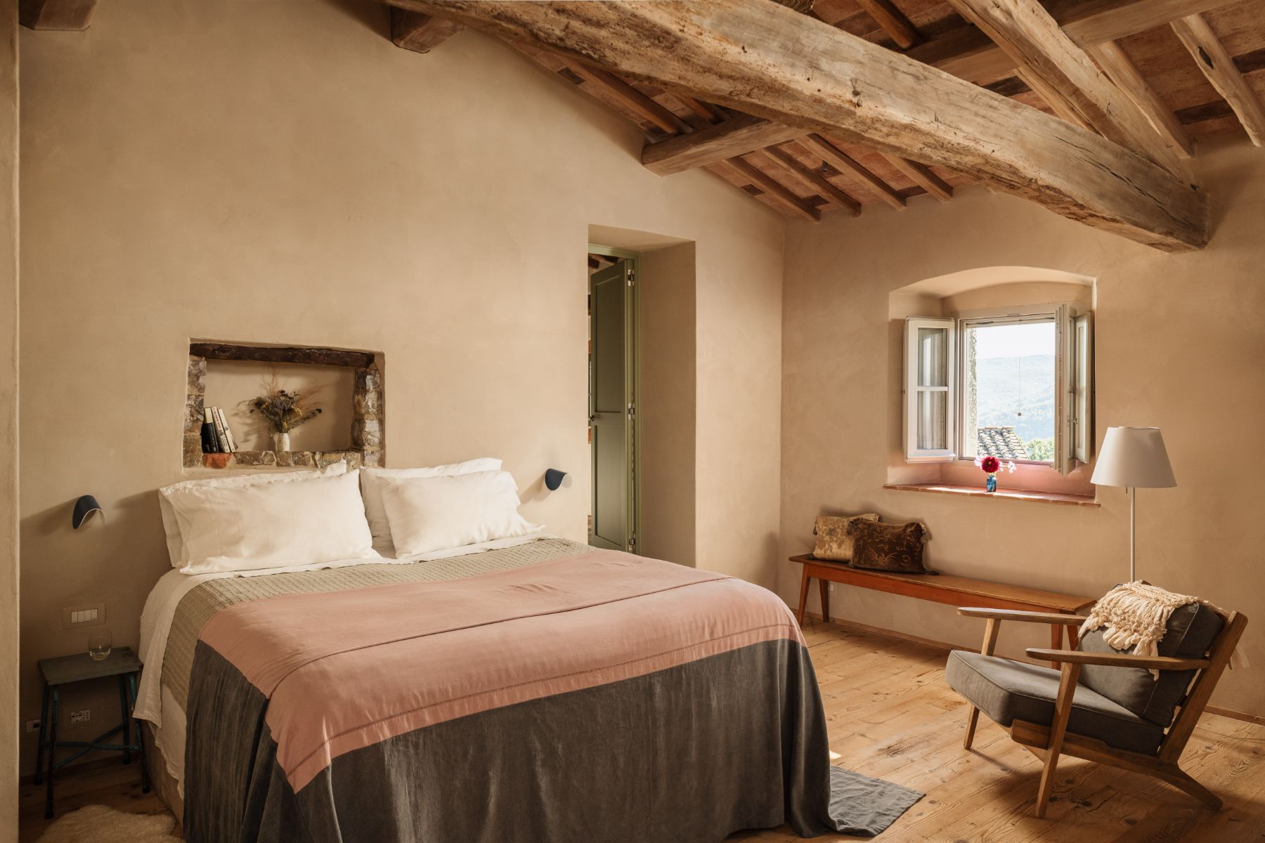 Bedroom with a double bed and an armchair at La Regina in Tuscany