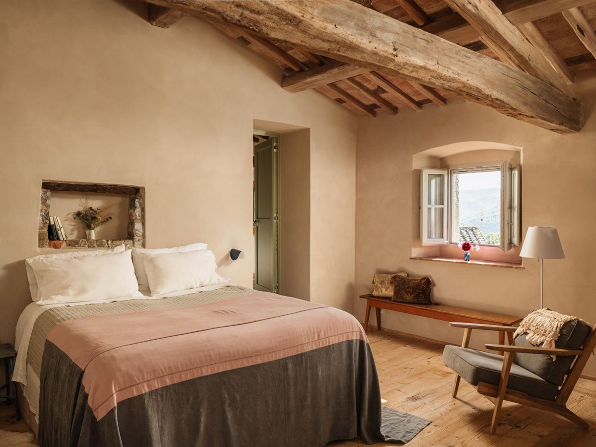 Bedroom with a double bed and an armchair at La Regina in Tuscany