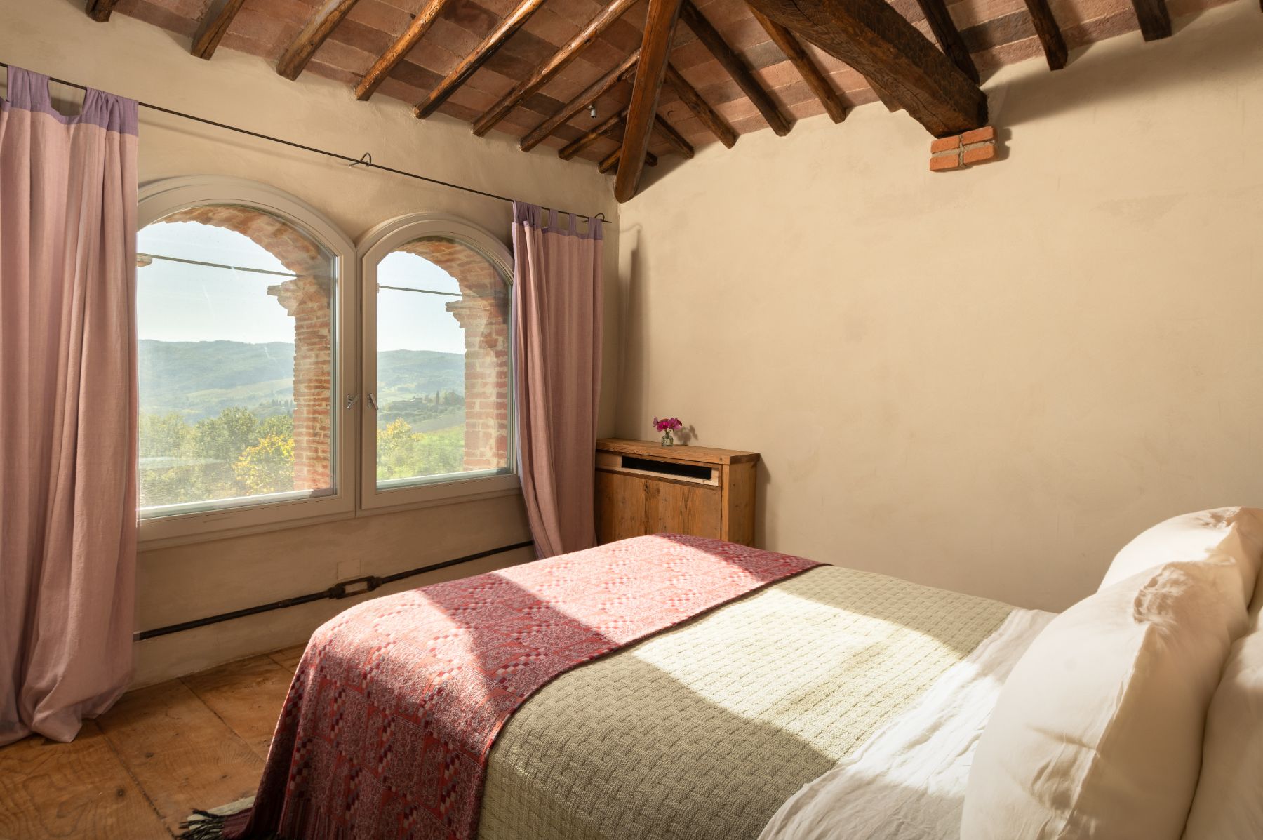 Bedroom with double bed and large windows at La Regina in Tuscany