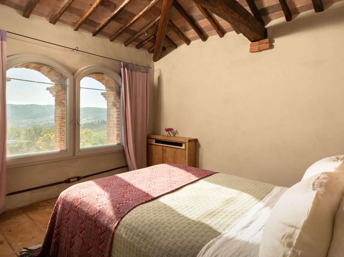 Bedroom with double bed and large windows at La Regina in Tuscany