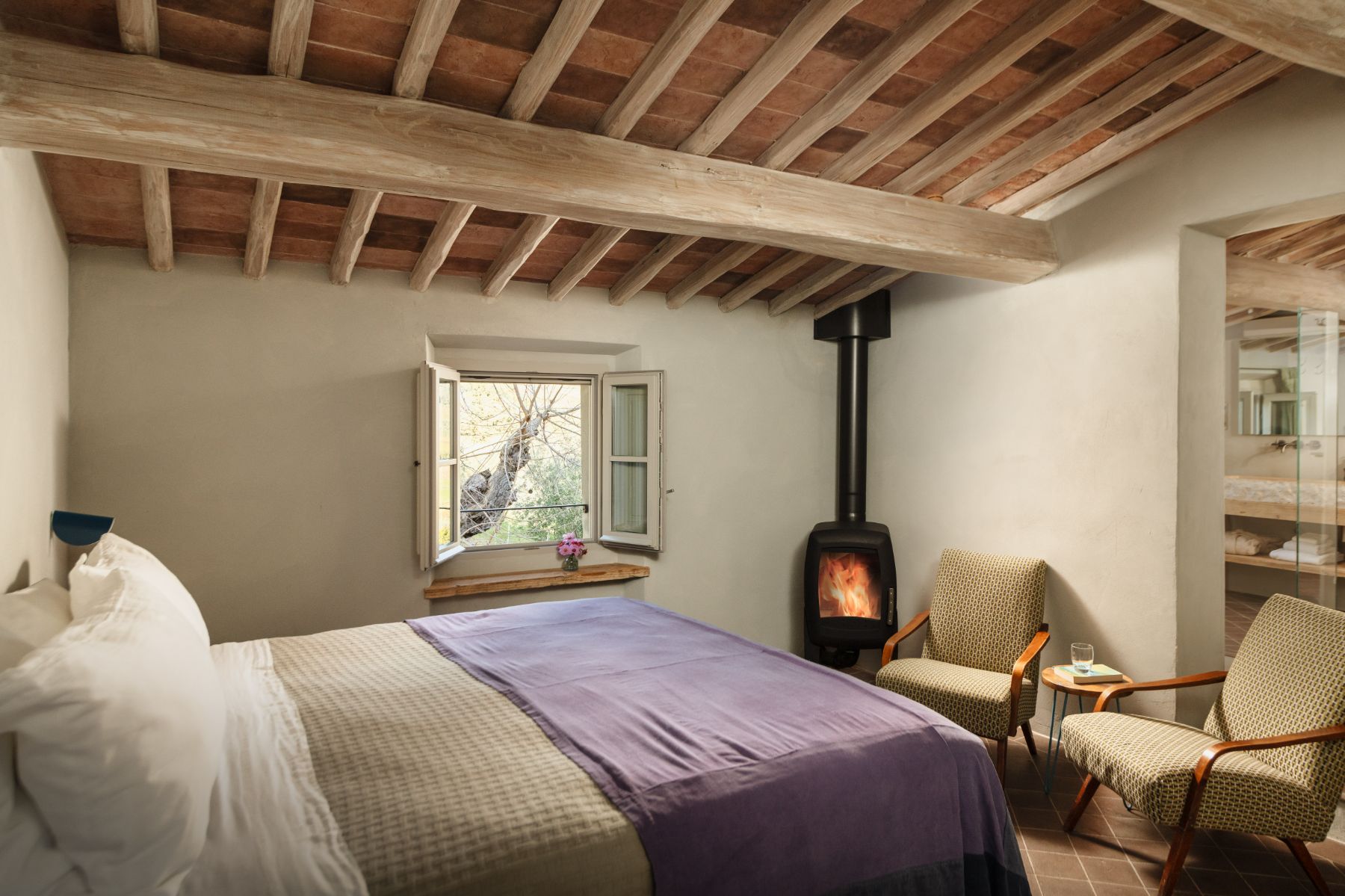 Bedroom with a double bed and small fireplace at La Regina in Tuscany