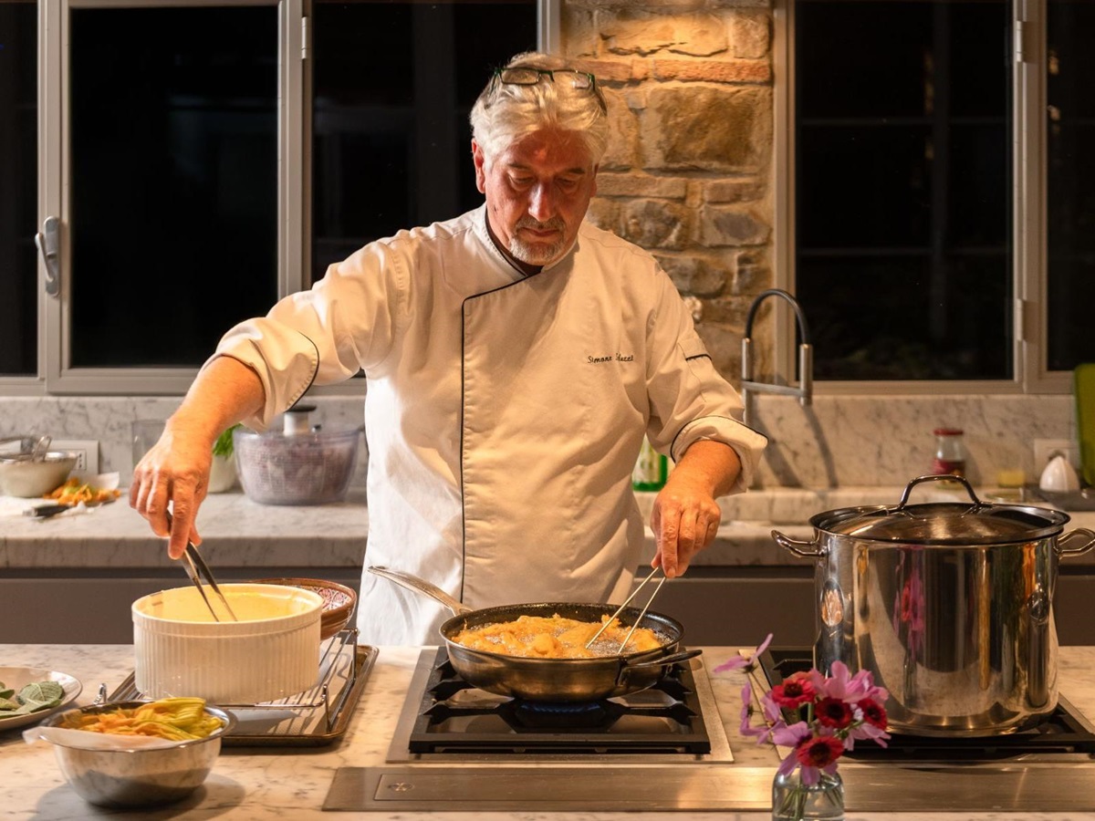 Chef in the kitchen at La Regina in Tuscany cooking food