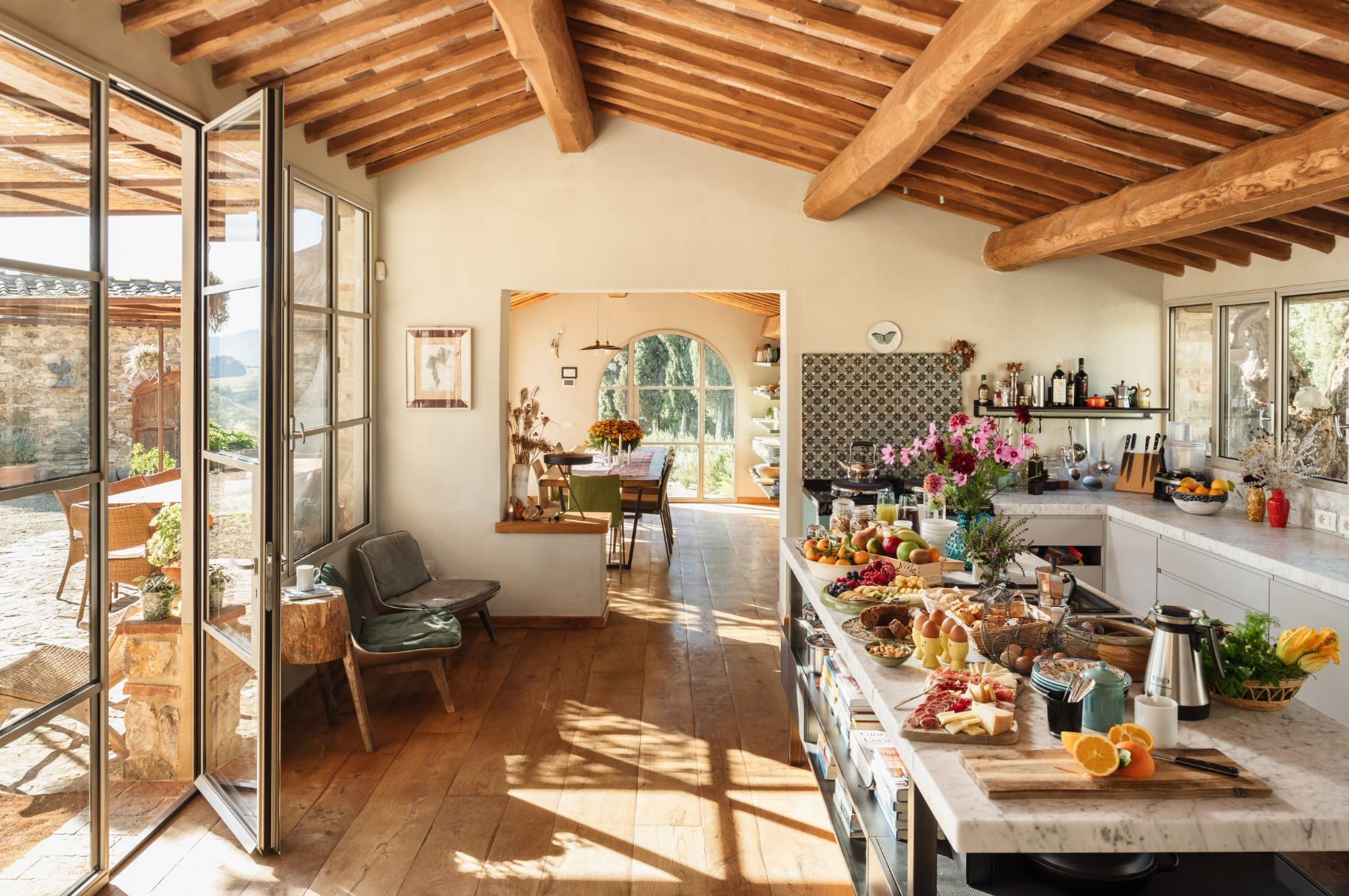Kitchen area with view of the indoor dining room and the outdoor area at La Regina in Tuscany