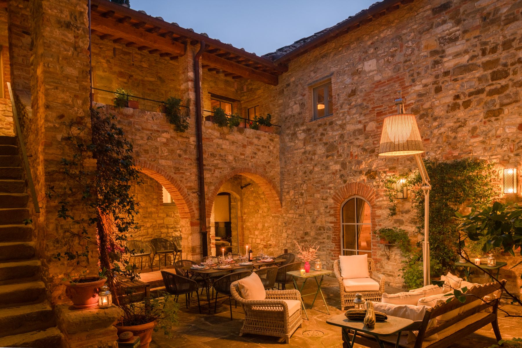Outdoor courtyard area with dining areas and sofas at La Regina in Tuscany