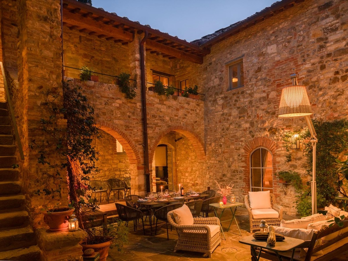 Outdoor courtyard area with dining areas and sofas at La Regina in Tuscany