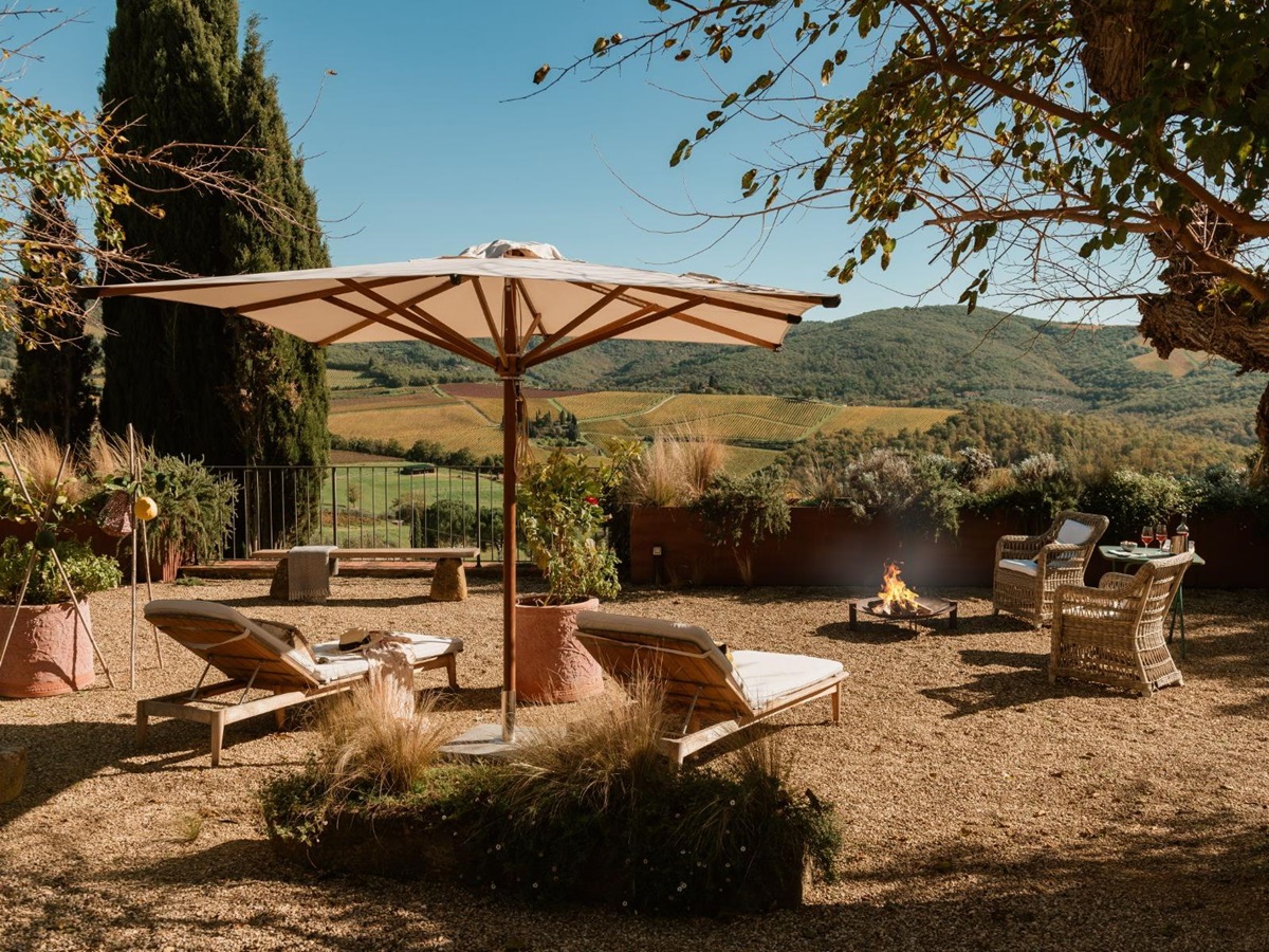 Outdoor fireplace with sun loungers at La Regina in Tuscany