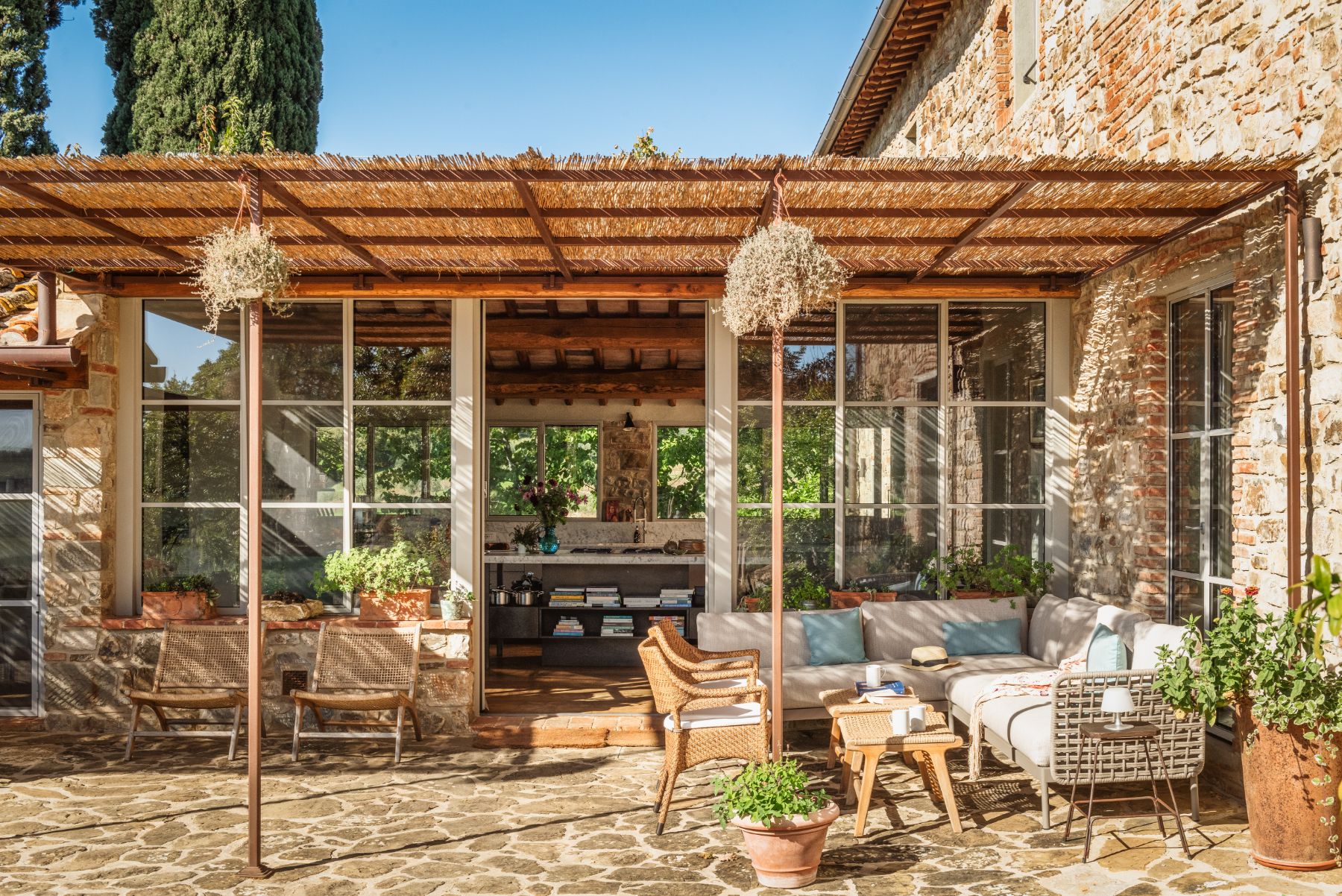 Outdoor lounge area with sofas near to the kitchen at La Regina in Tuscany
