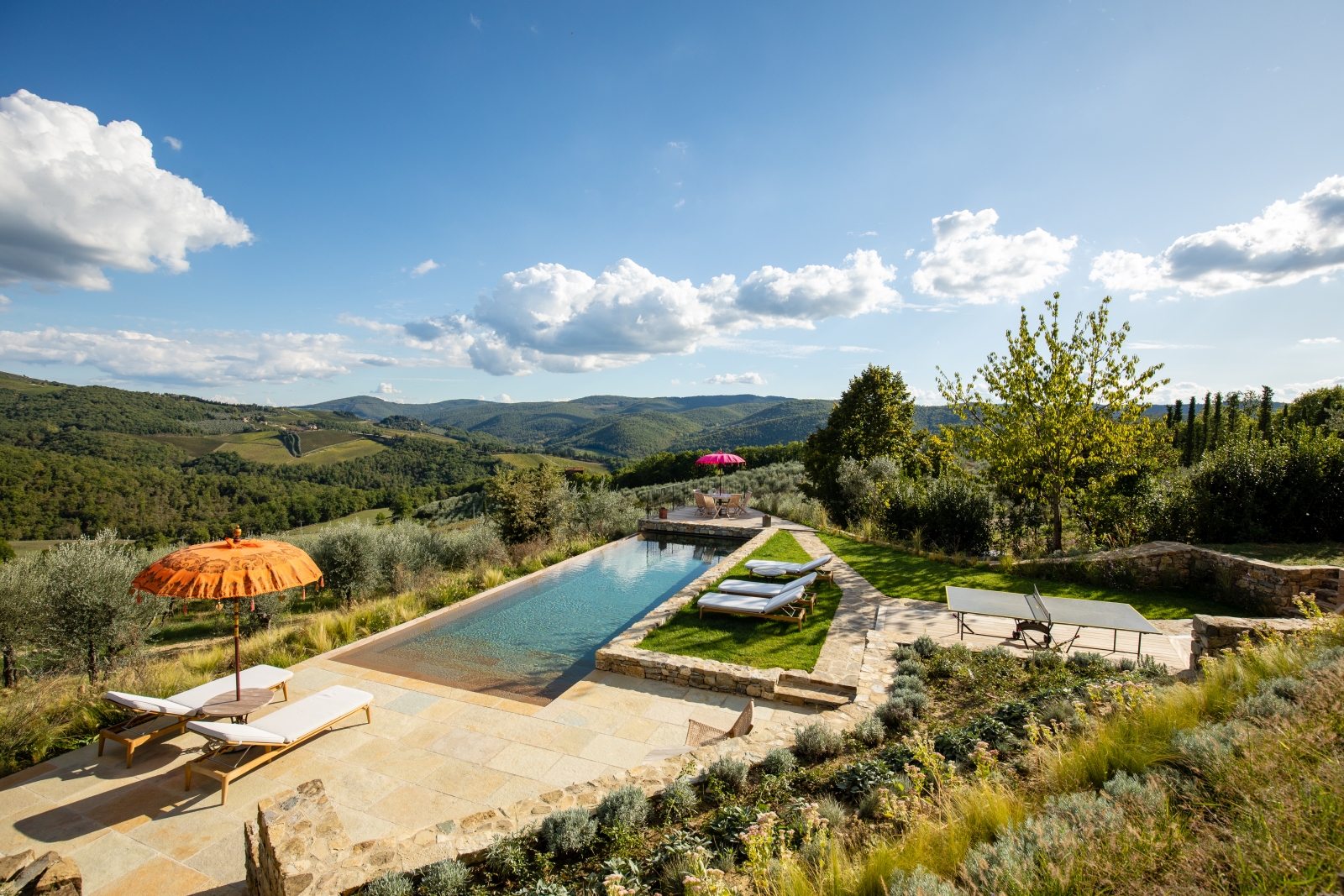 Pool and pool area with sun loungers, umbrellas, table tennis and countryside views at La Regina in Tuscany, Italy