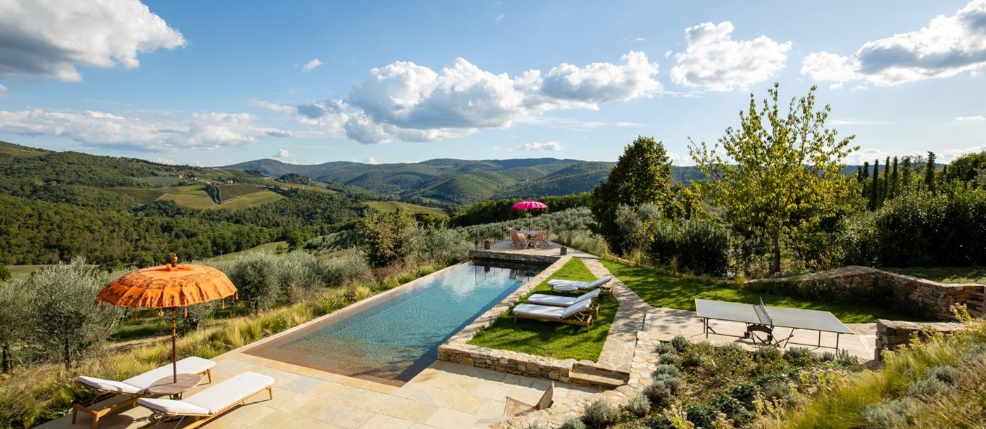 Pool and pool area with sun loungers, umbrellas, table tennis and countryside views at La Regina in Tuscany, Italy