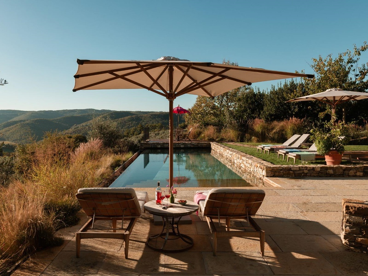 Pool area with sun loungers and parasols at La Regina in Tuscany