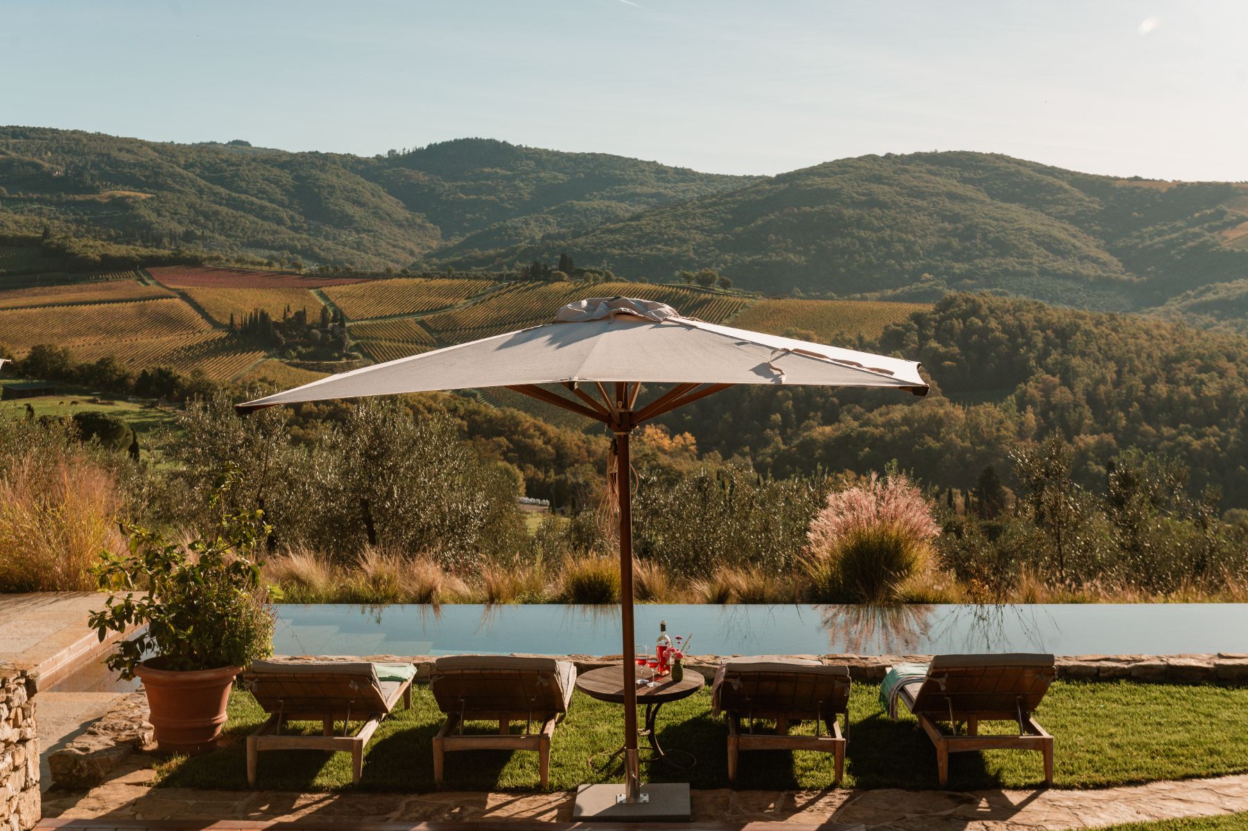 Pool area with views of the Tuscan hills and the sun beds at La Regina
