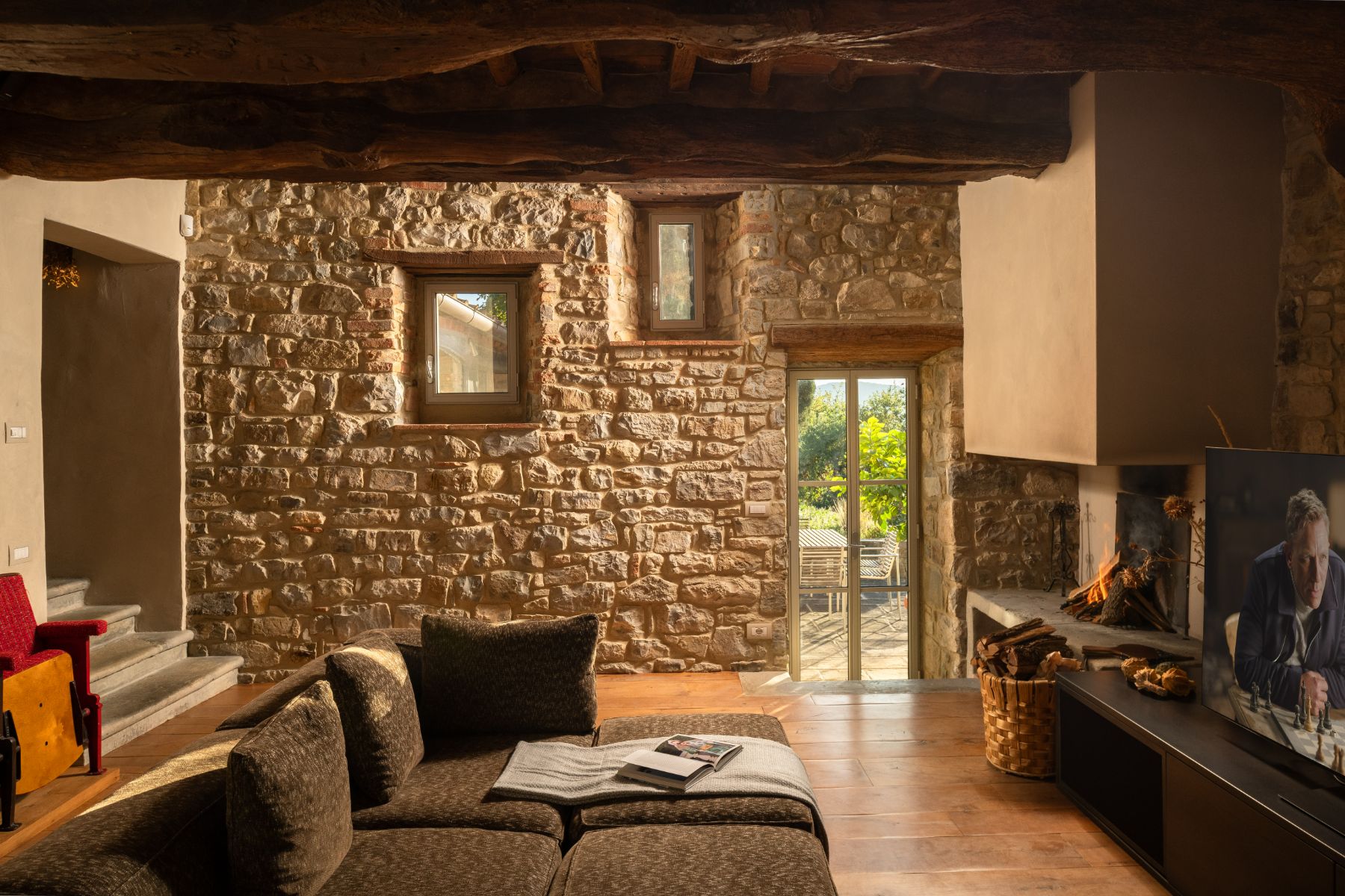 Television room with sofas and a television on the wall at La Regina in Tuscany