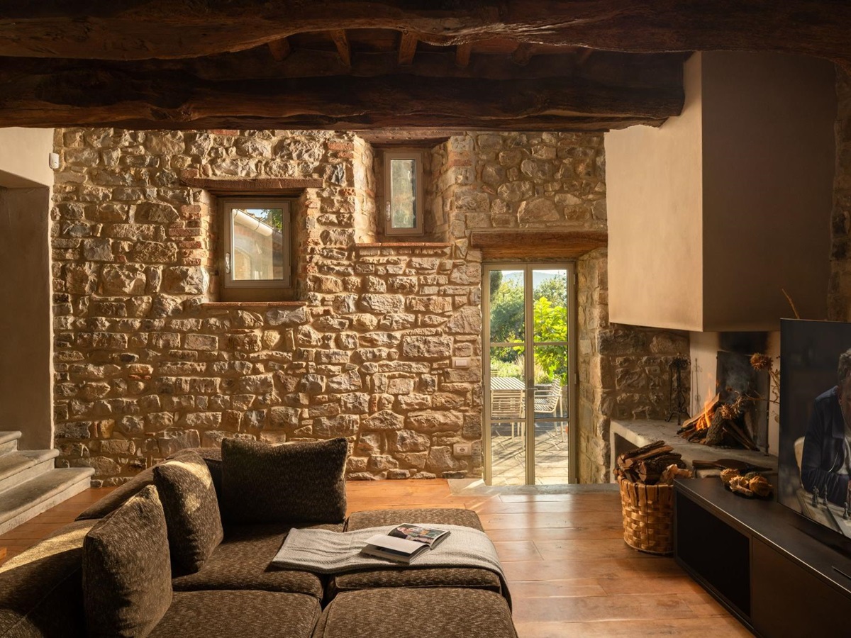 Television room with sofas and a television on the wall at La Regina in Tuscany