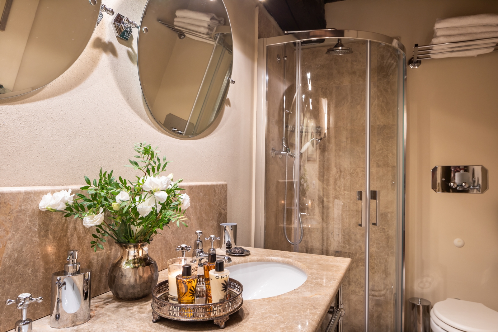 bathroom with shower and round mirrors at la tenuta in tuscany