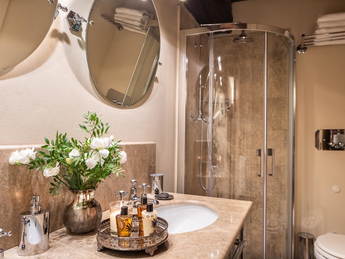 bathroom with shower and round mirrors at la tenuta in tuscany