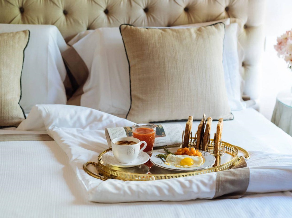 A cooked breakfast and coffee prepared on a tray in bed at La Tenuta.