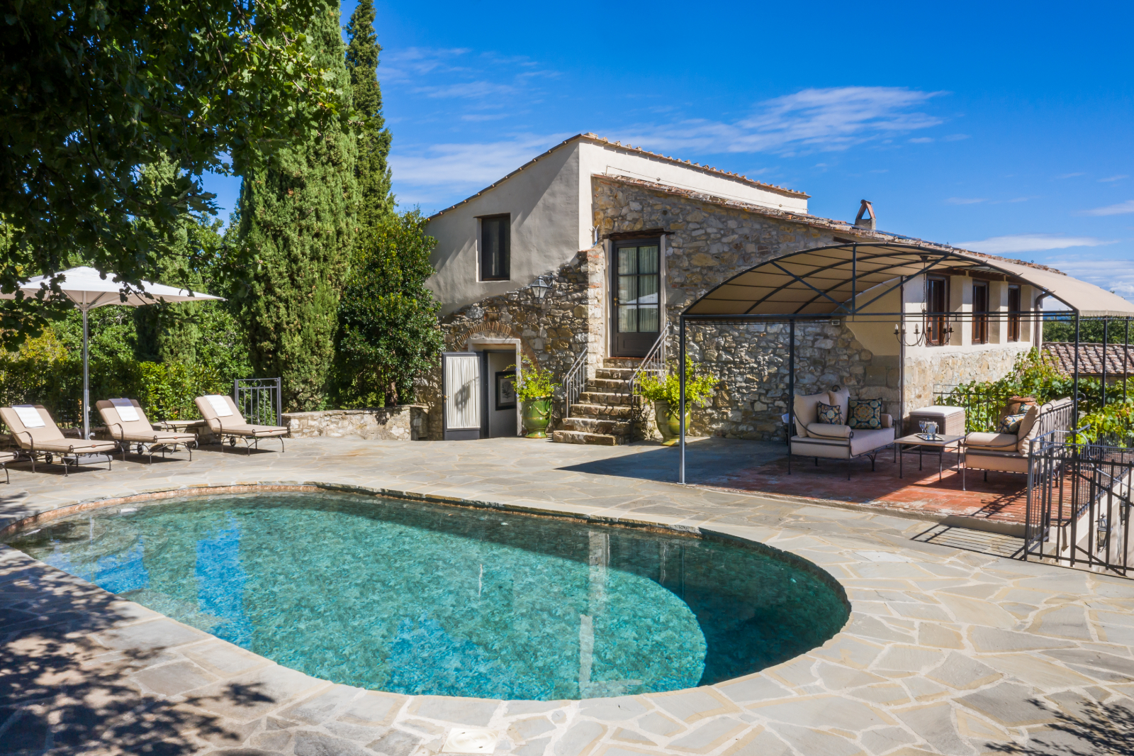Pool with sun-loungers and exterior of villa at la tenuta, tuscany