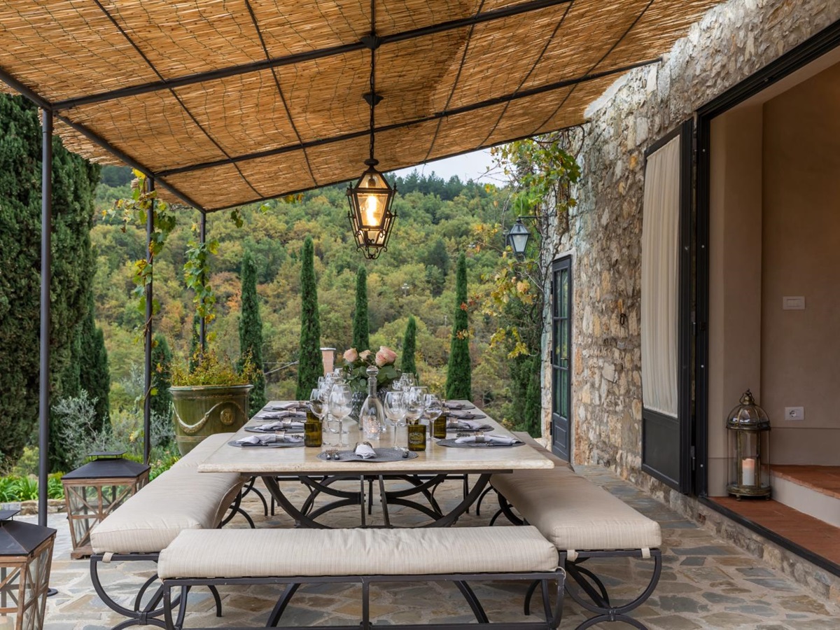 Table under a pergola set for lunch at la tenuta, tuscany