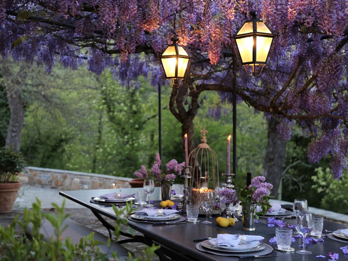 Al fresco dining with blooming wisteria pergola at la tenuta, tuscany