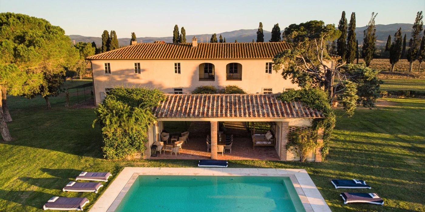 Aerial shot of villa, covered outdoor dining area, garden and pool at La Vigna in Tuscany, Italy