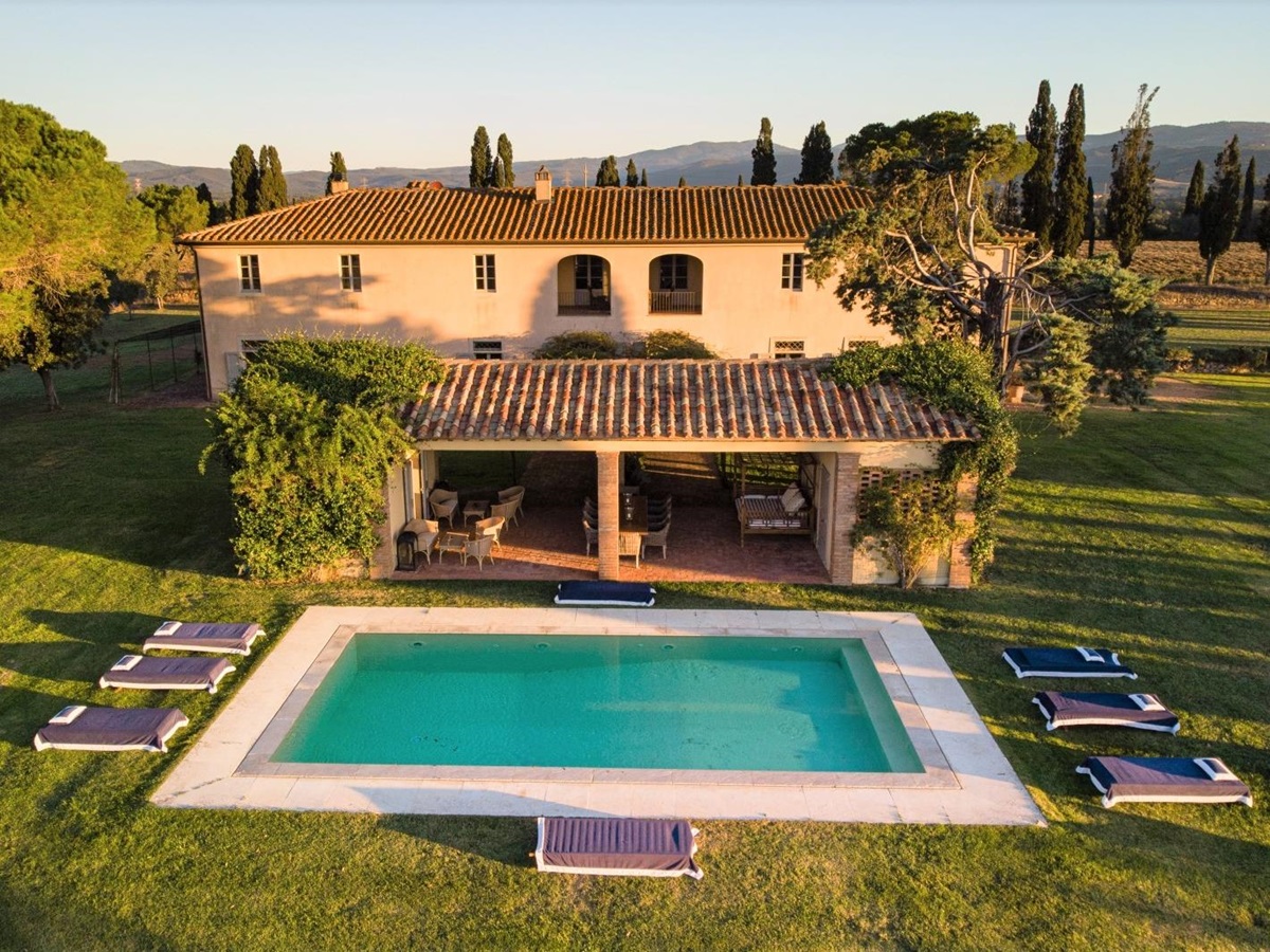 Aerial shot of villa, covered outdoor dining area, garden and pool at La Vigna in Tuscany, Italy