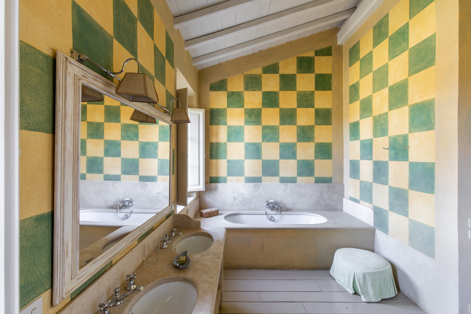 Bathroom with yellow & green walls, two sinks, large mirror, window and bath at La Vigna in Tuscany, Italy