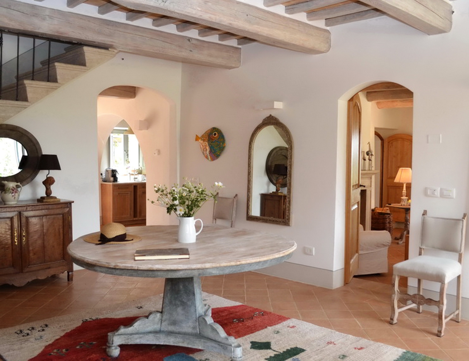 Hallway with round table and beamed ceiling at Podere Caterina in Tuscany