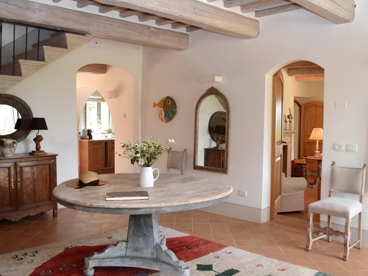 Hallway with round table and beamed ceiling at Podere Caterina in Tuscany
