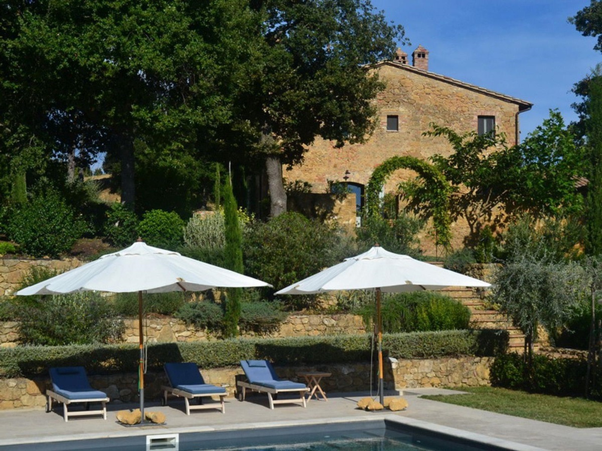 Pool loungers with villa in the background at Podere Caterina in Tuscany