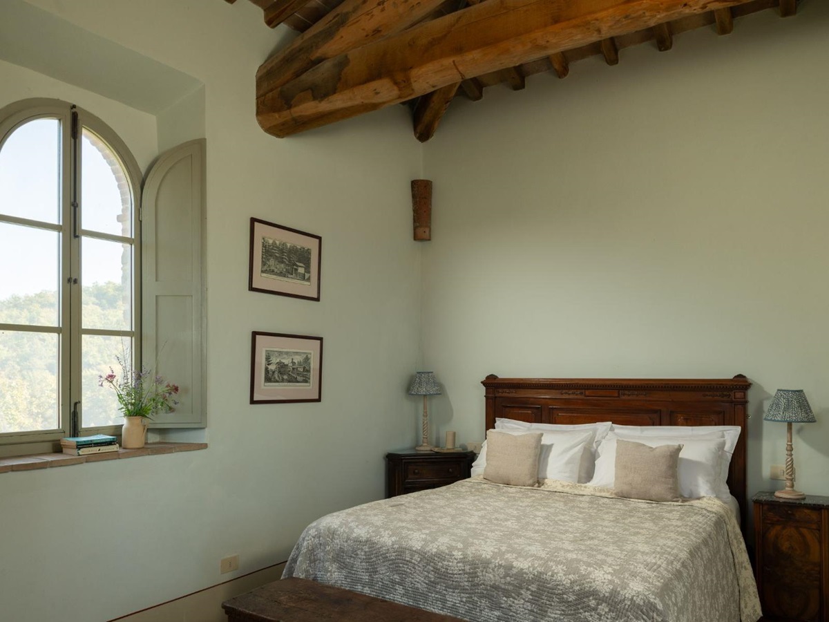 Bedroom with double bed and a large window at Podere Cipressi in Tuscany