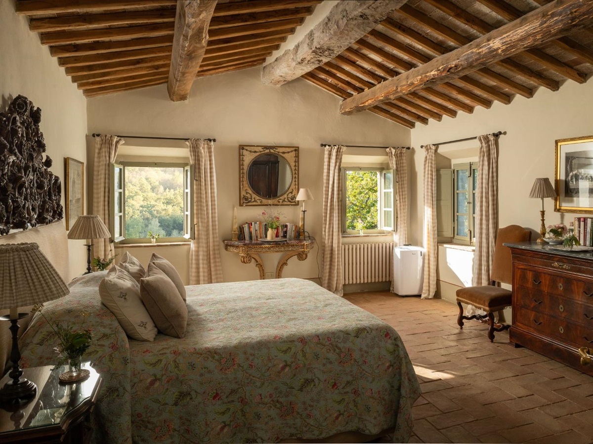 Large bedroom with double bed and wooden beams at Podere Cipressi in Tuscany