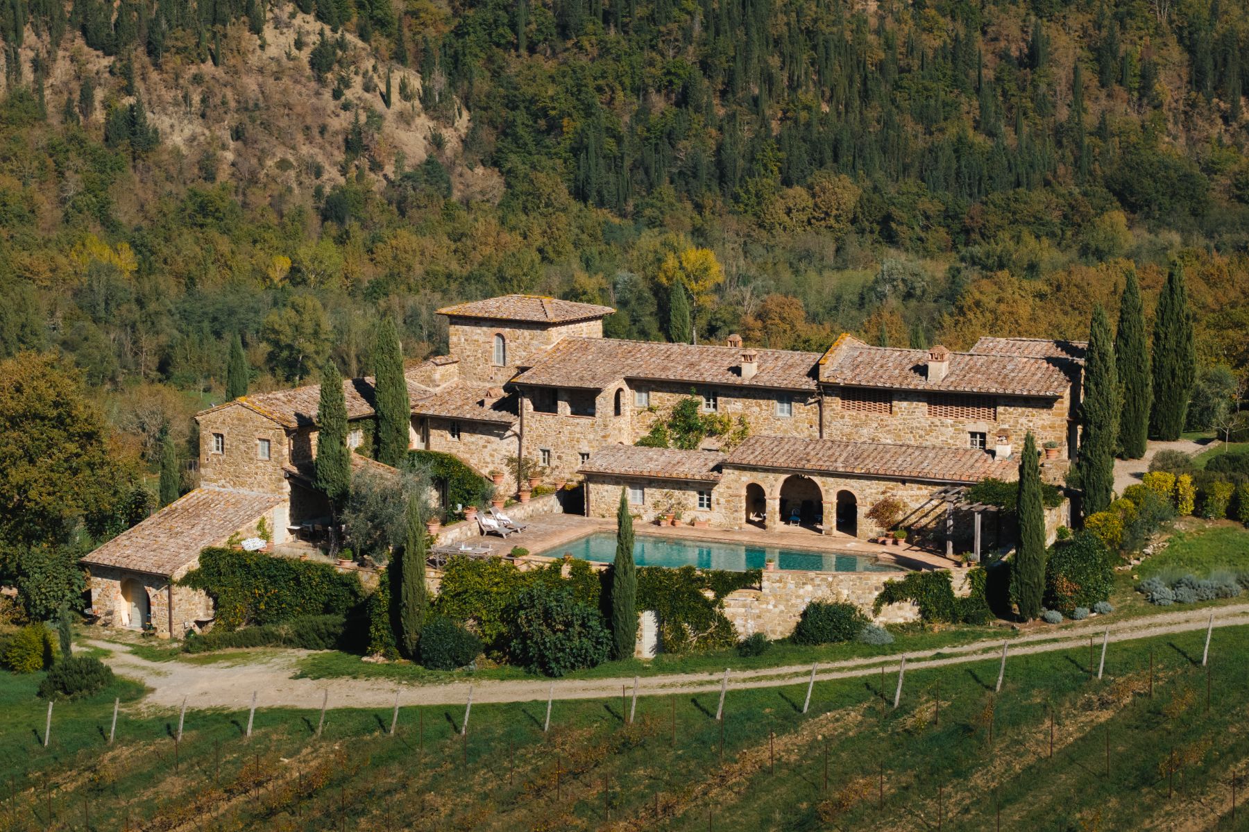 Drone view of Podere Cipressi with view of the villa and pool area in Tuscany