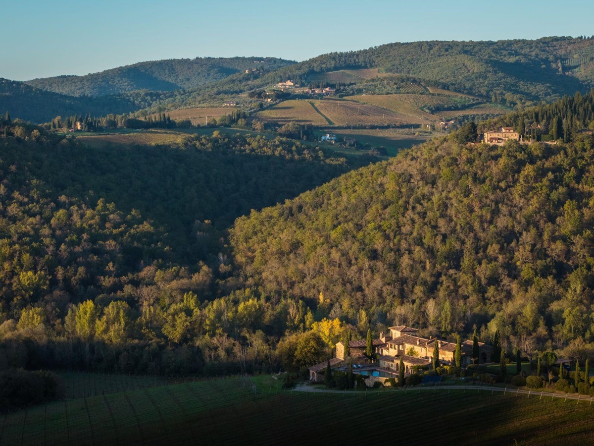 Drone view of Podere Cipressi surrounded by Tuscan hills and trees