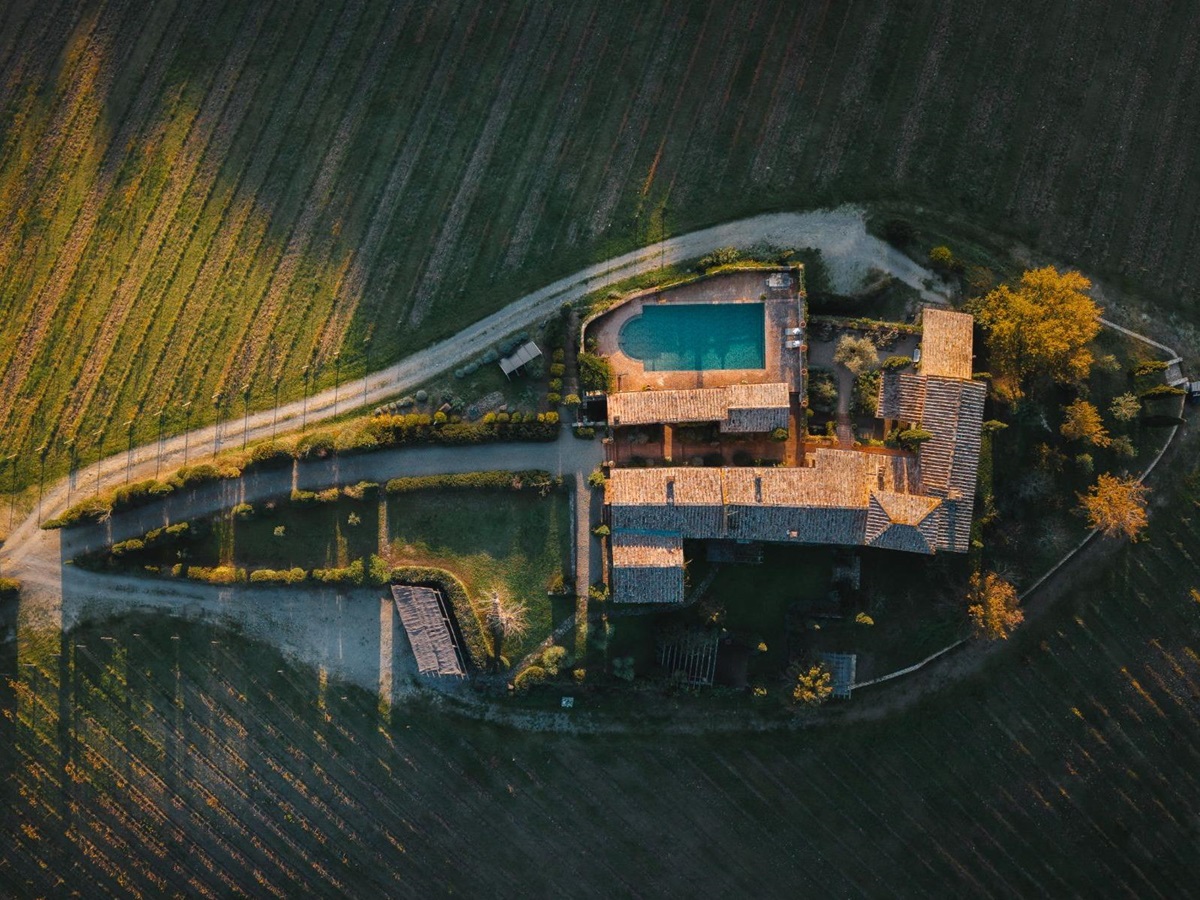 Overhead drone view of Podere Cipressi and the pool area and driveway in Tuscany