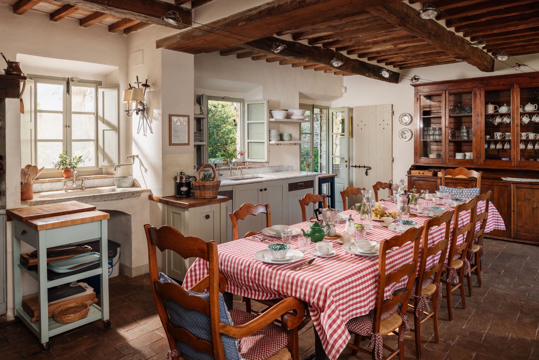 Traditional Tuscan kitchen with a long wooden table at Podere Cipressi