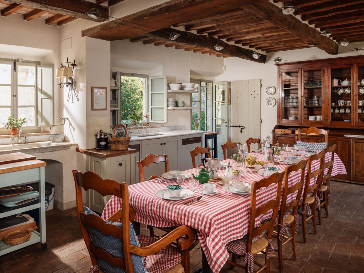 Traditional Tuscan kitchen with a long wooden table at Podere Cipressi