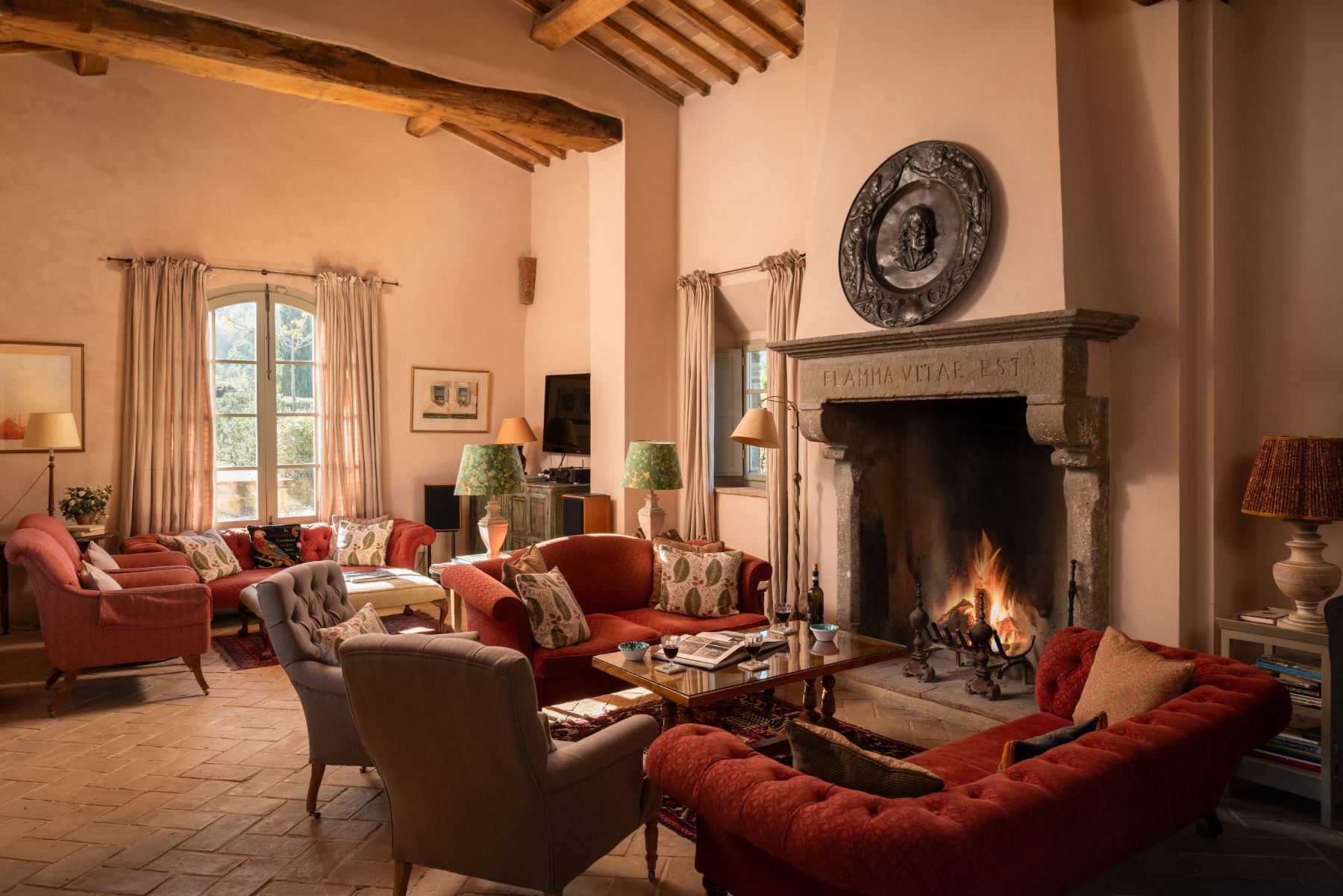Living room with sofas and a large fireplace at Podere Cipressi in Tuscany