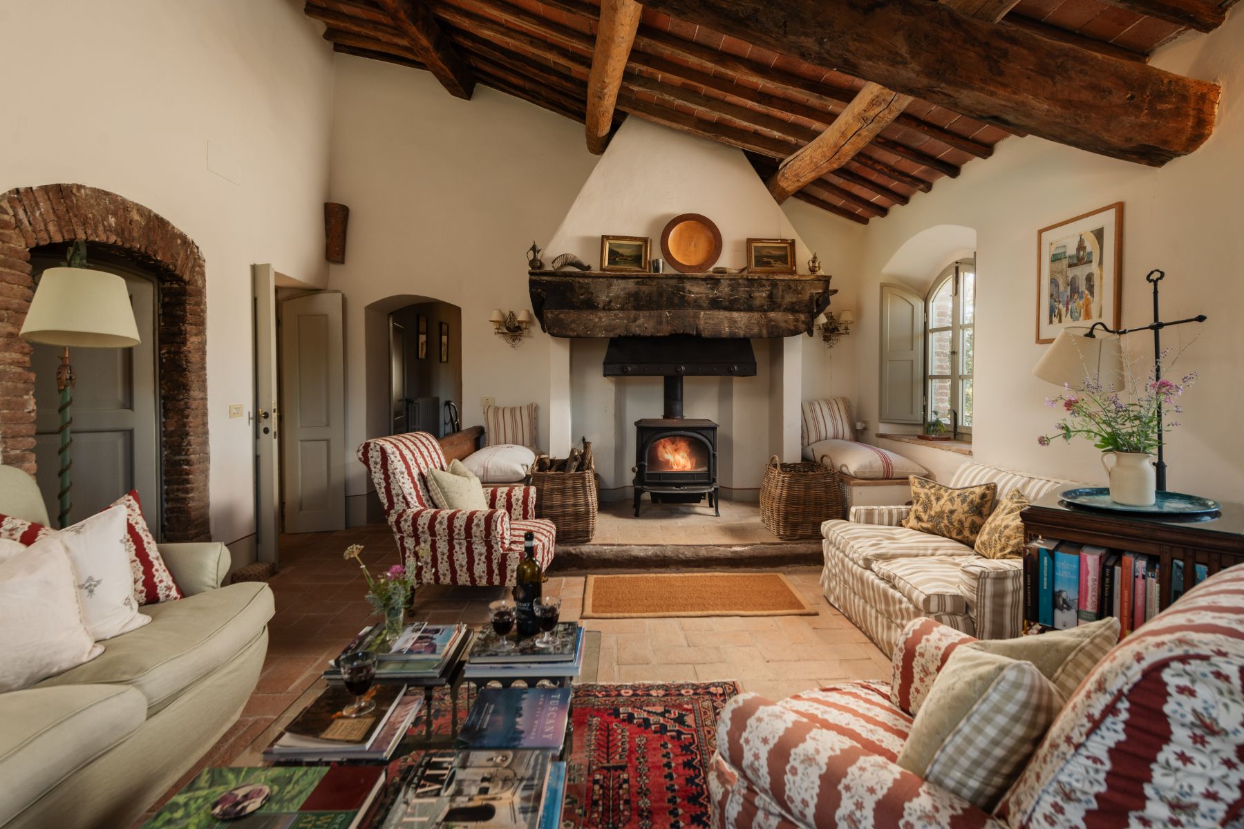 Living room with sofas armchairs and a fireplace at Podere Cipressi in Tuscany