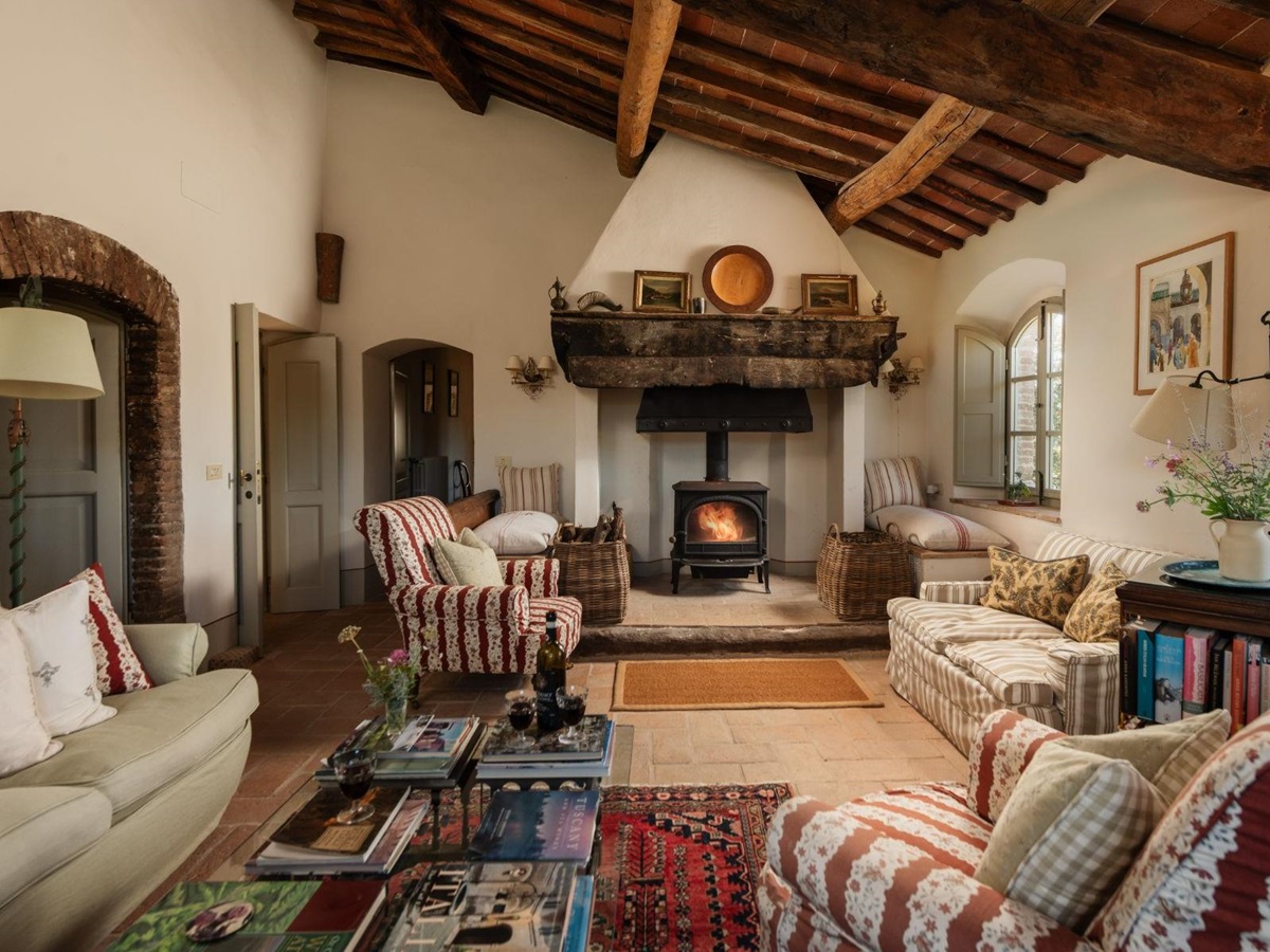 Living room with sofas armchairs and a fireplace at Podere Cipressi in Tuscany