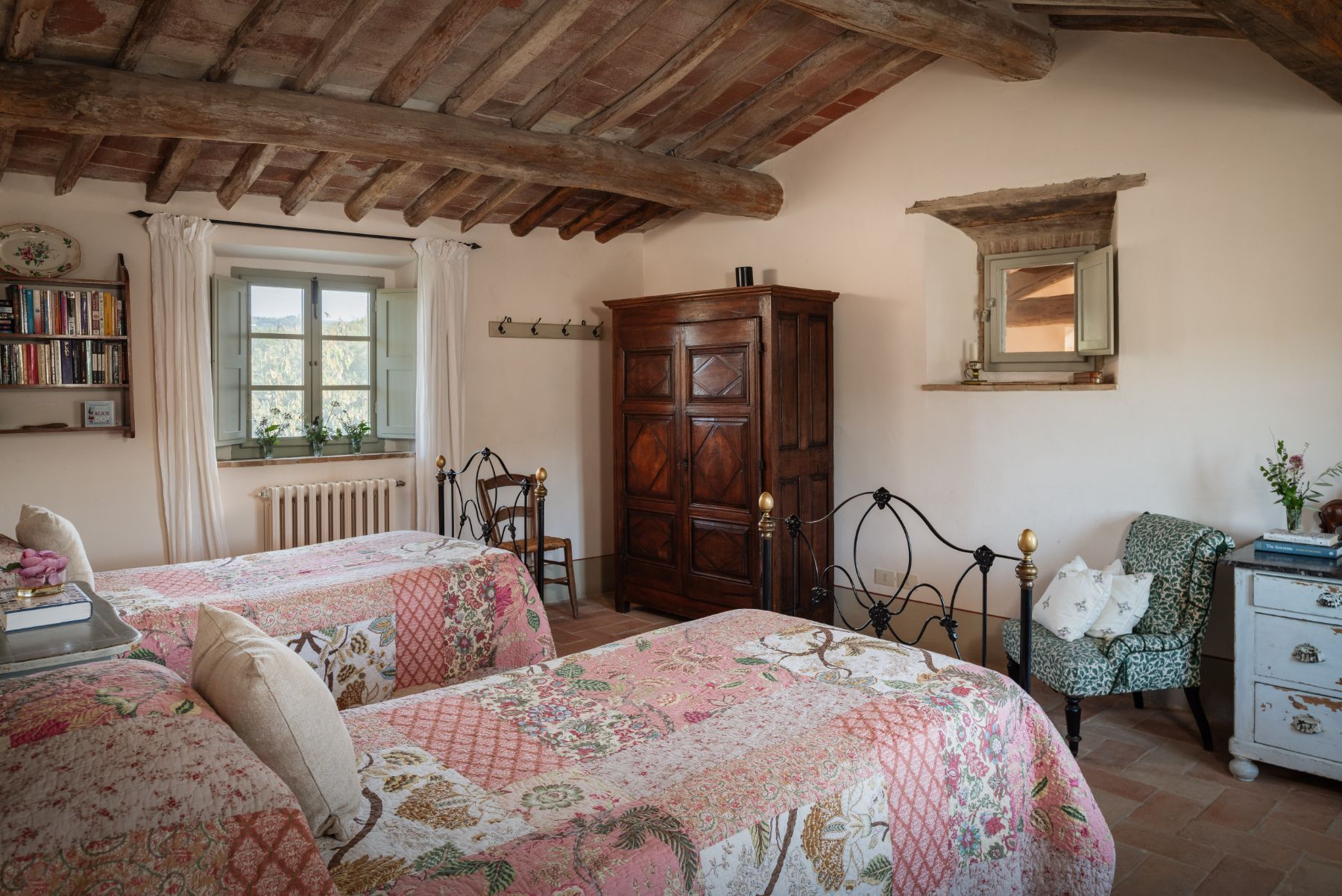 Twin room with a wooden wardrobe and armchair at Podere Cipressi in Tuscany