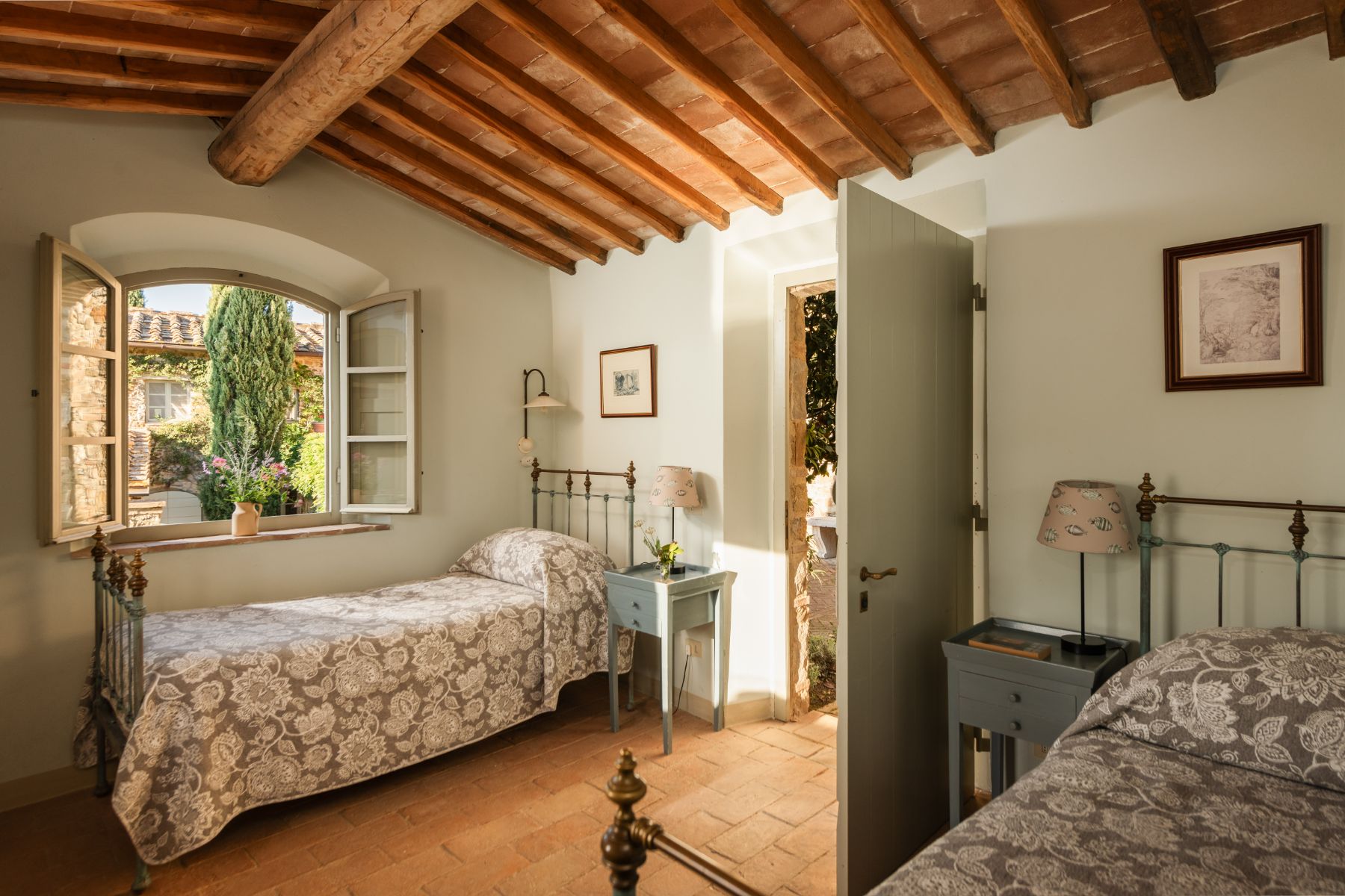 Twin room with a large window and wooden beams at Podere Cipressi in Tuscany