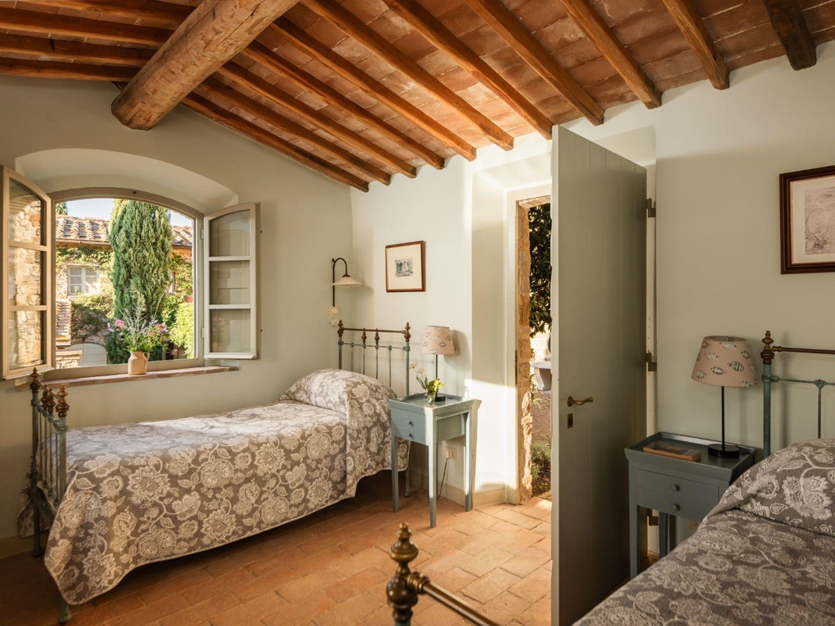 Twin room with a large window and wooden beams at Podere Cipressi in Tuscany