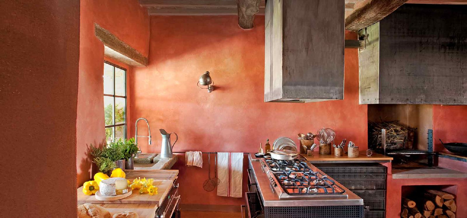 Kitchen with large counters and red walls at Podere Due Scale