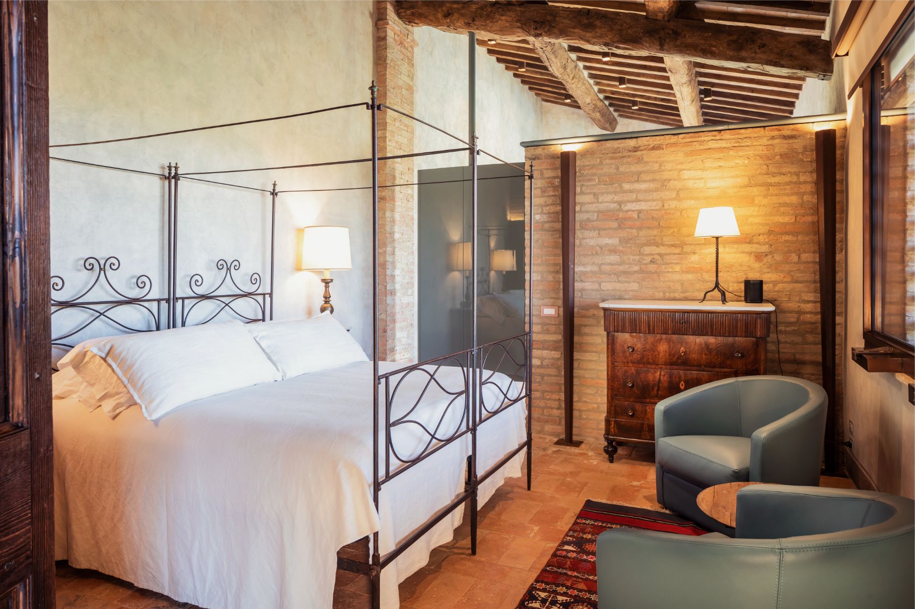 Double bedroom with blue chairs at Podere Martino in Tuscany