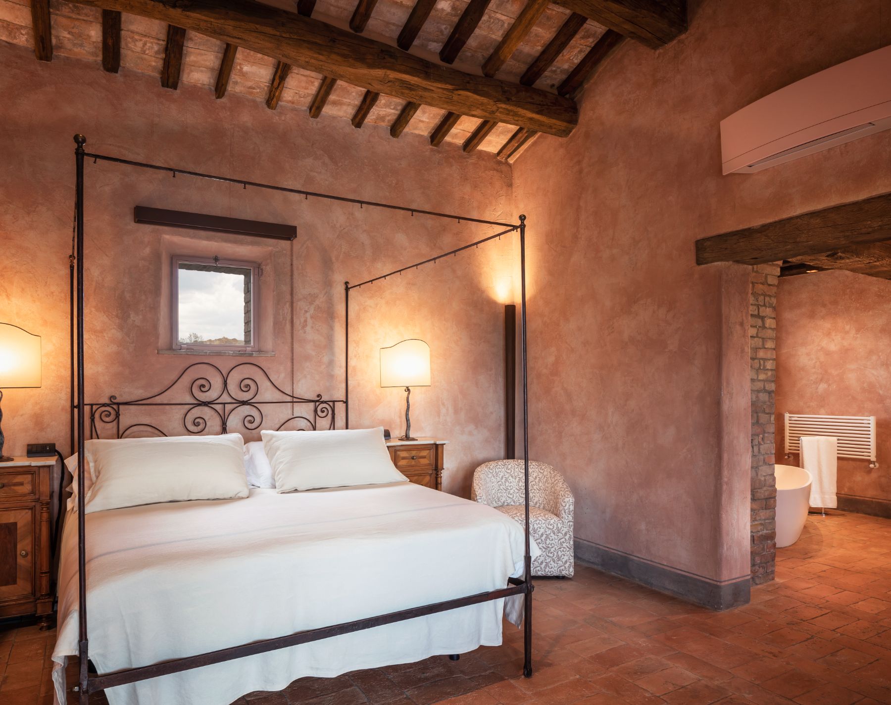 Double bedroom with black bed frame at Podere Martino in Tuscany